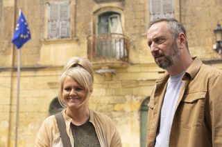 Jean (Sally Lindsay) and Dom (Steve Edge) stand outside in the street in Sainte Victoire
