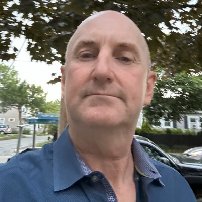 A headshot of a man in a blue shirt