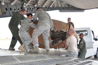 Air Force reservists load recovered rocket parts during a 2011 trip to Mongolia. The debris was identified as expended hardware from an Air Force booster that circled Earth for nearly a decade.
