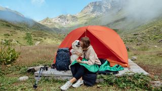 Woman in tent with her dog