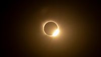 A totally eclipsed sun is pictured in a black sky.