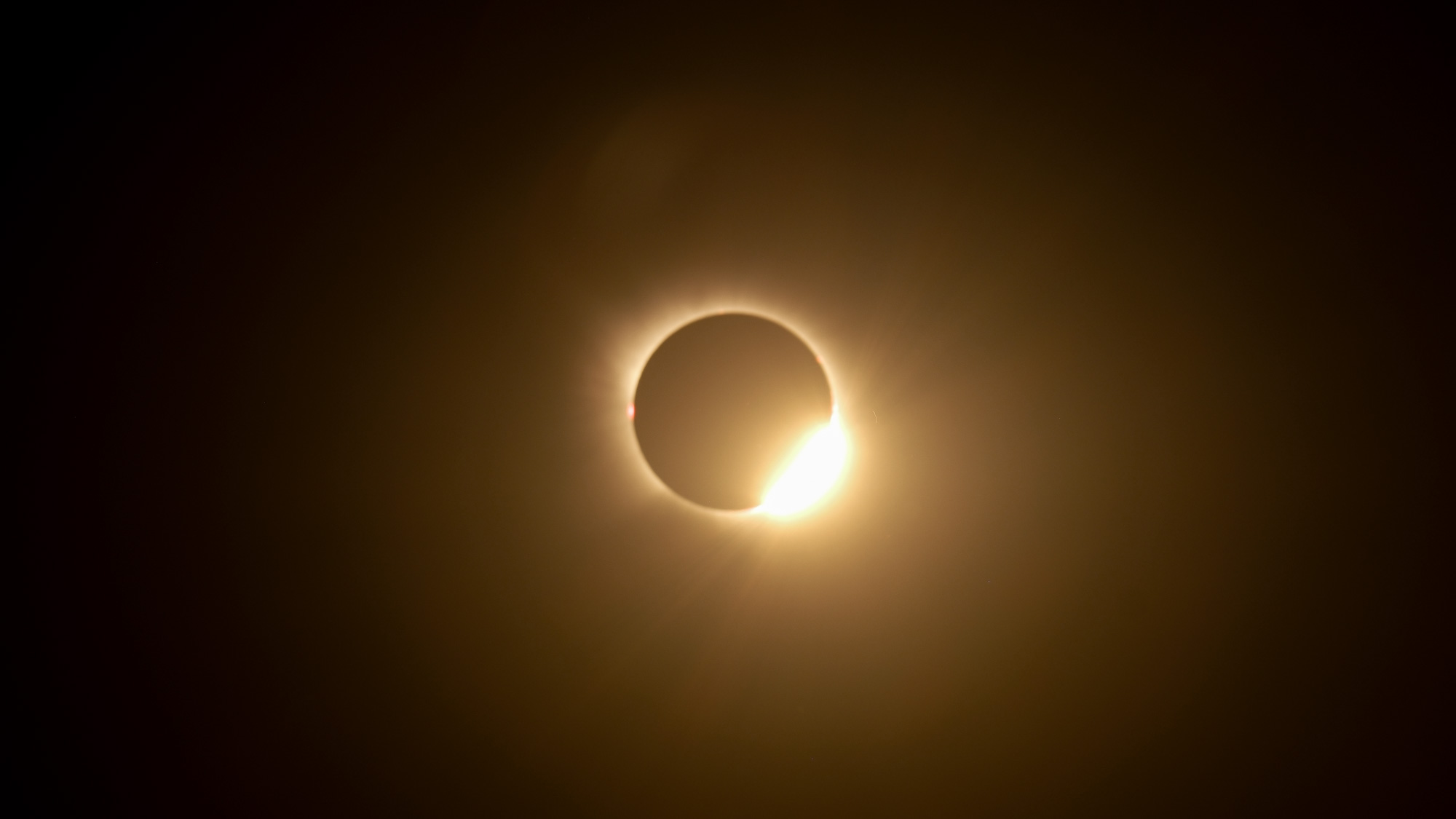 A totally eclipsed sun is pictured in a black sky.