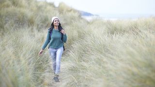 Woman walking on sand dunes