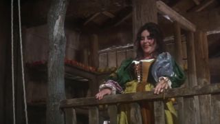 Elizabeth Taylor smiling on a wood balcony in The Taming Of The Shrew