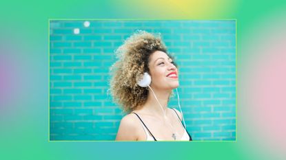 woman listening to her music via headphones on blue colorful background