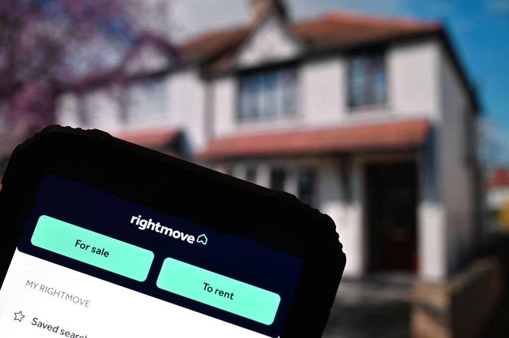 In this photo illustration, the Rightmove app is displayed on a smartphone in front of a UK house.