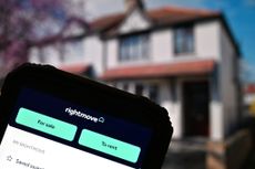 In this photo illustration, the Rightmove app is displayed on a smartphone in front of a UK house.