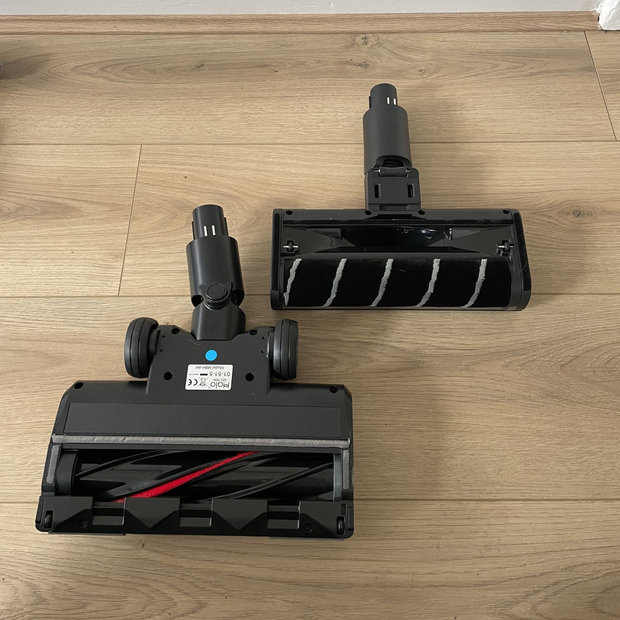 Two floorheads of the Halo Capsule XR laying on wood-effect flooring