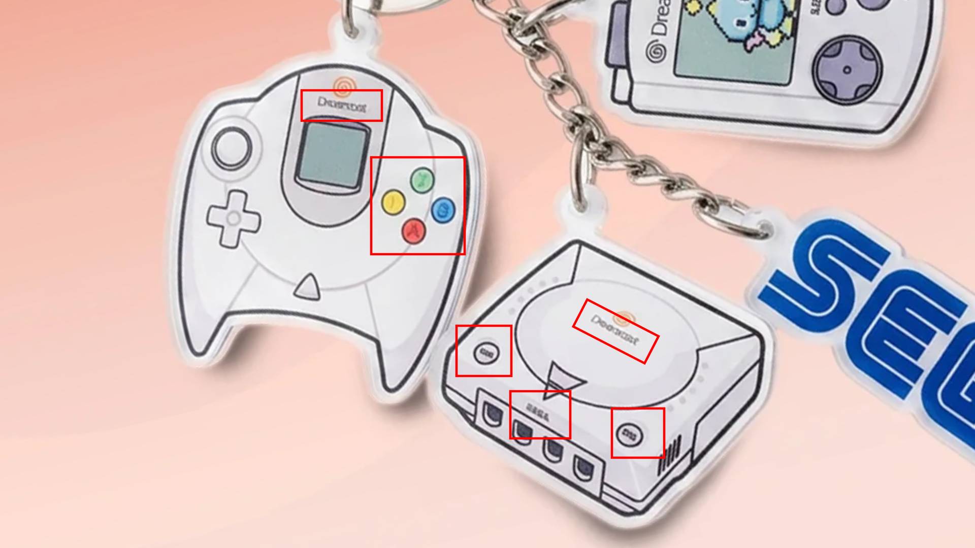 Sega Dreamcast keychain with controller and red boxes highlighting text seemingly altered by AI.