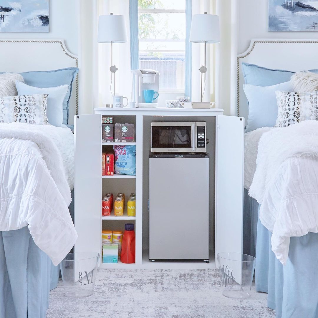 Lemari di antara dua tempat tidur berisi makanan ringan dan microwave