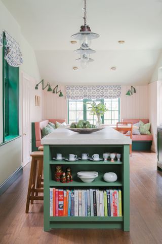 bright green and pink kitchen with mint green island unit and green window frame in distance with green wall lamps
