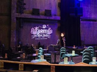 The stage at Hilarities Theatre in a low bluish light.