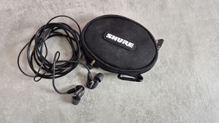 Shure SE215 next to carry case