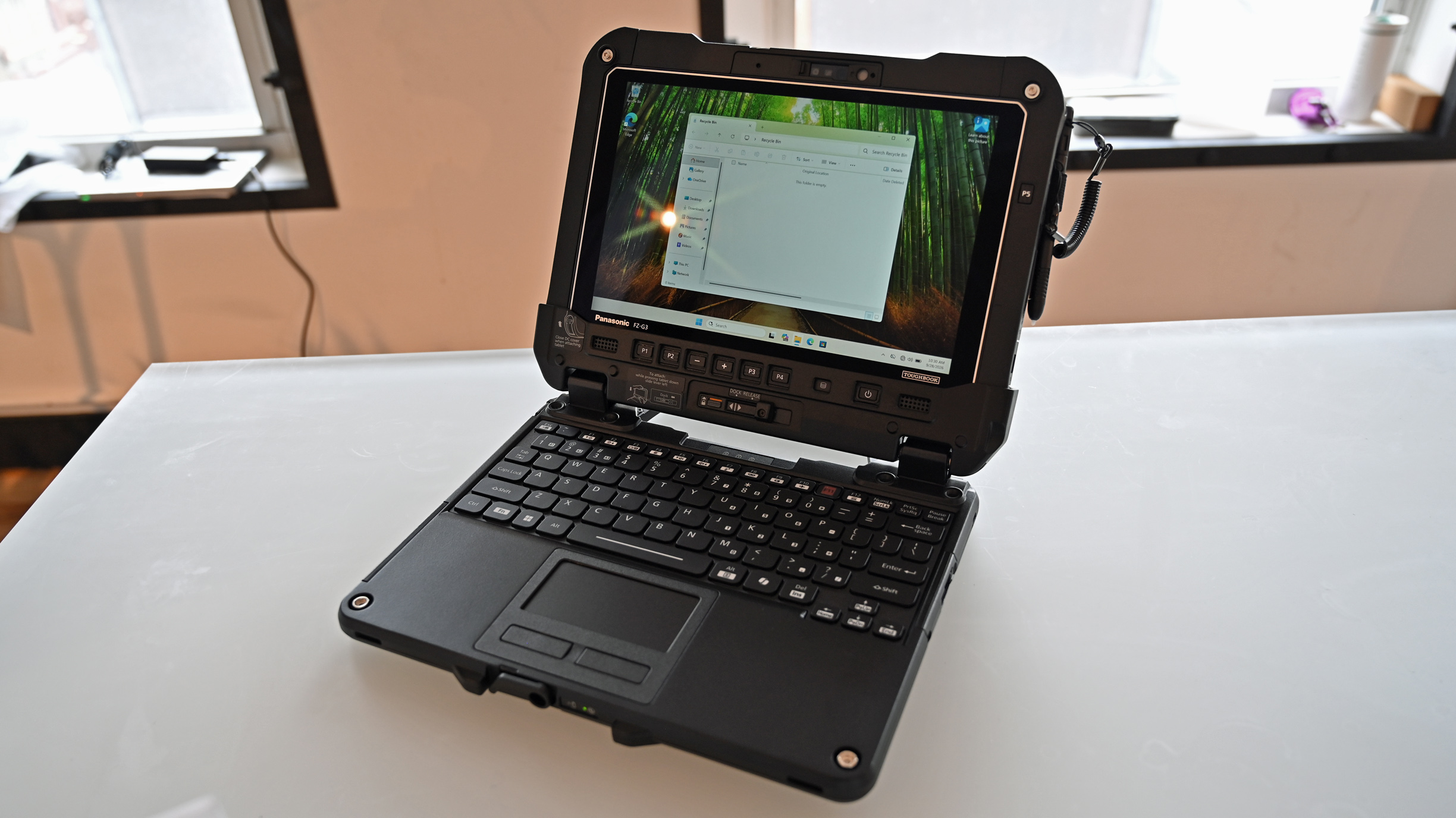 A Panasonic TOUGHBOOK G3 rugged tablet docked to a keyboard base, standing open on a white desk like a laptop.
