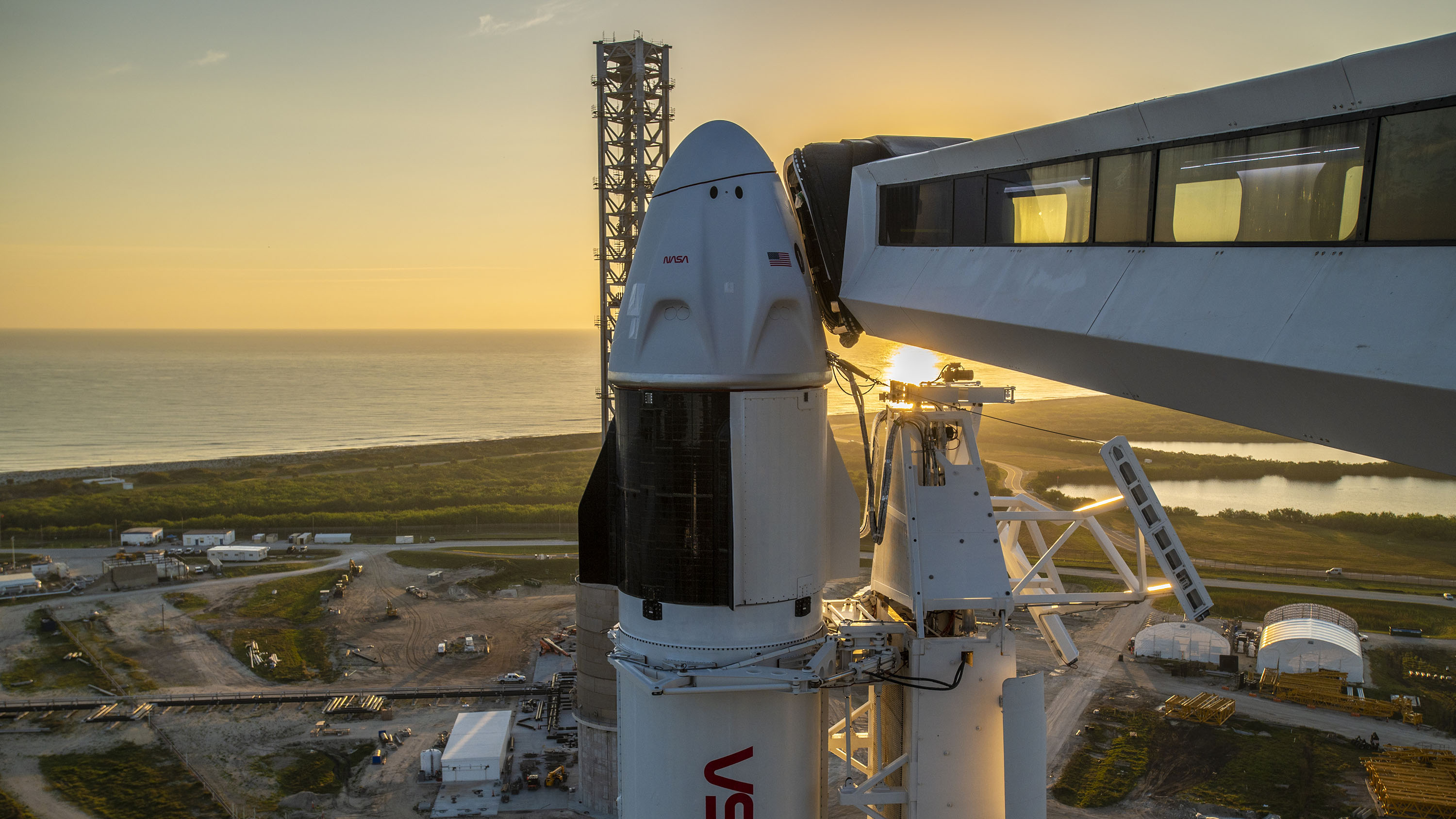 The sun rises behind SpaceX's Crew Dragon Endeavour and Falcon 9 rocket at Launch Pad 39A of NASA's Kennedy Space Center for Crew-6.