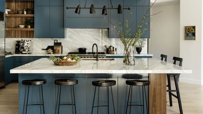 kitchen with blue cabinetry, marble backsplash and with wooden floors