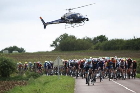 A helicopter hovers over the Tour de France peloton in 2024