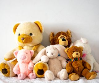 Collection of stuffed toys and teddy bears on a bed