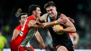 Port Adelaide's Jordon Sweet is tackled by Sydney's Tom McCartin ahead of the 2024 AFL Preliminary Final live stream between the two sides.