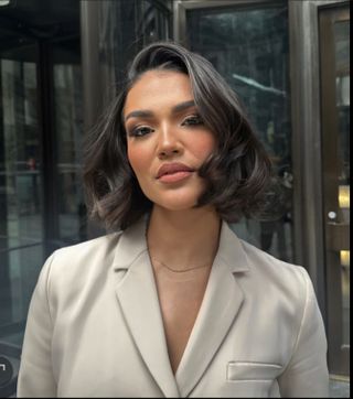 A woman with a voluminous, curly bob hairstyle