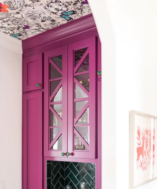 Colorful kitchen with pink cabinets and botanical butterfly wallpaper on ceiling