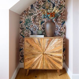 alcove with wallpaper and wooden cabinet