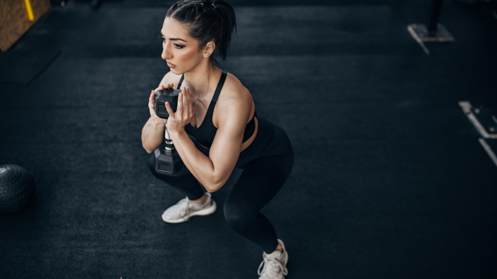 A woman performing dumbbell goblet squat