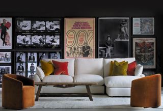 white sofa in black living room with movie posters