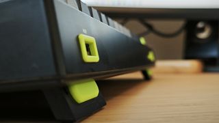 A black and green NuPhy Field75 keyboard on a wooden desk