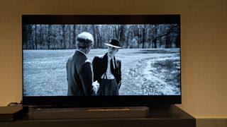 The Samsung S95F TV showing a black and white scene from Oppenheimer