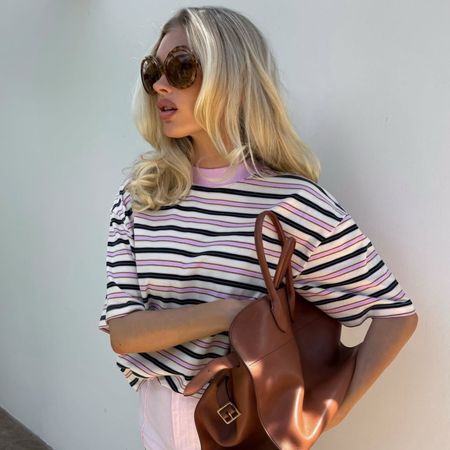 Model Elsa Hosk wears a striped t-shirt with pink shorts.