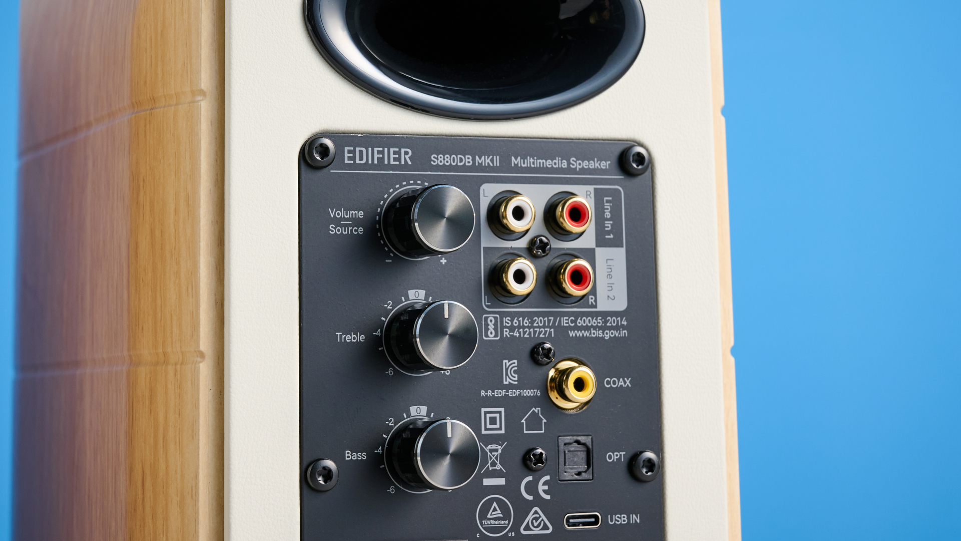 the edifier s880db mkii speakers in white and wood colorway showing the connectivity options, remote control, against a blue background