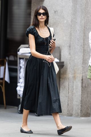 Kaia Gerber wearing a black Doen dress and ballet flats in NYC