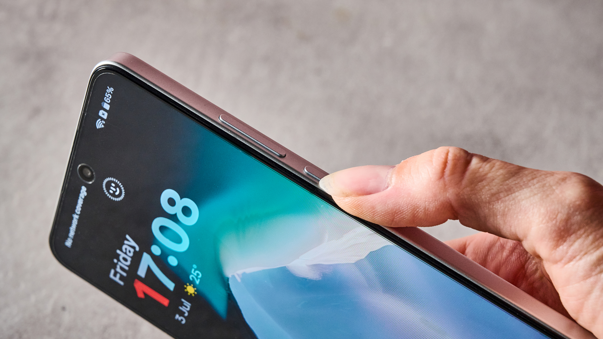A woman's hand pressing the lock button on the side of the OnePlus Nord CE5.