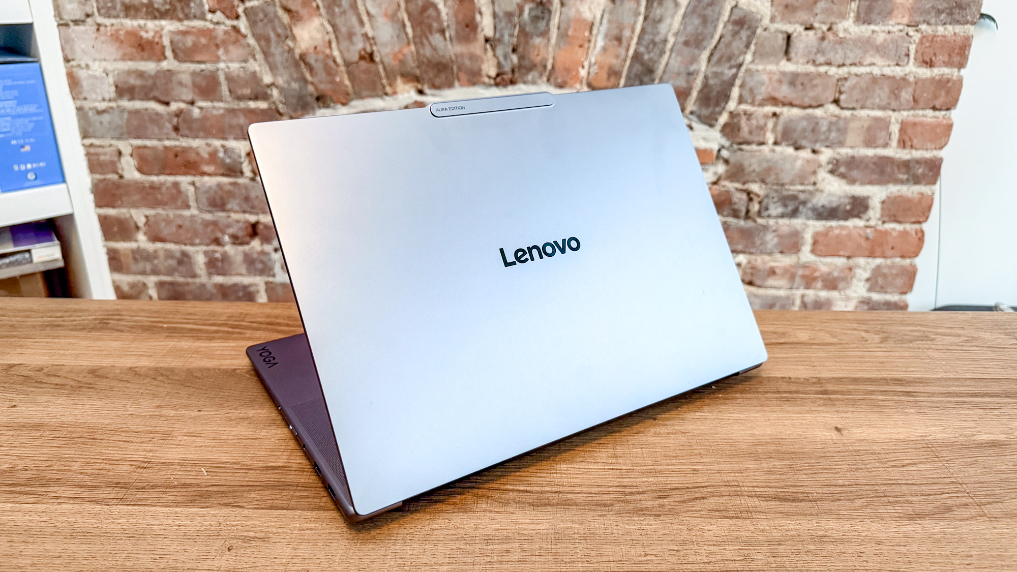 The Lenovo Yoga Pro 7i Gen 11 Aura Edition seen from behind with its lid open on a desk