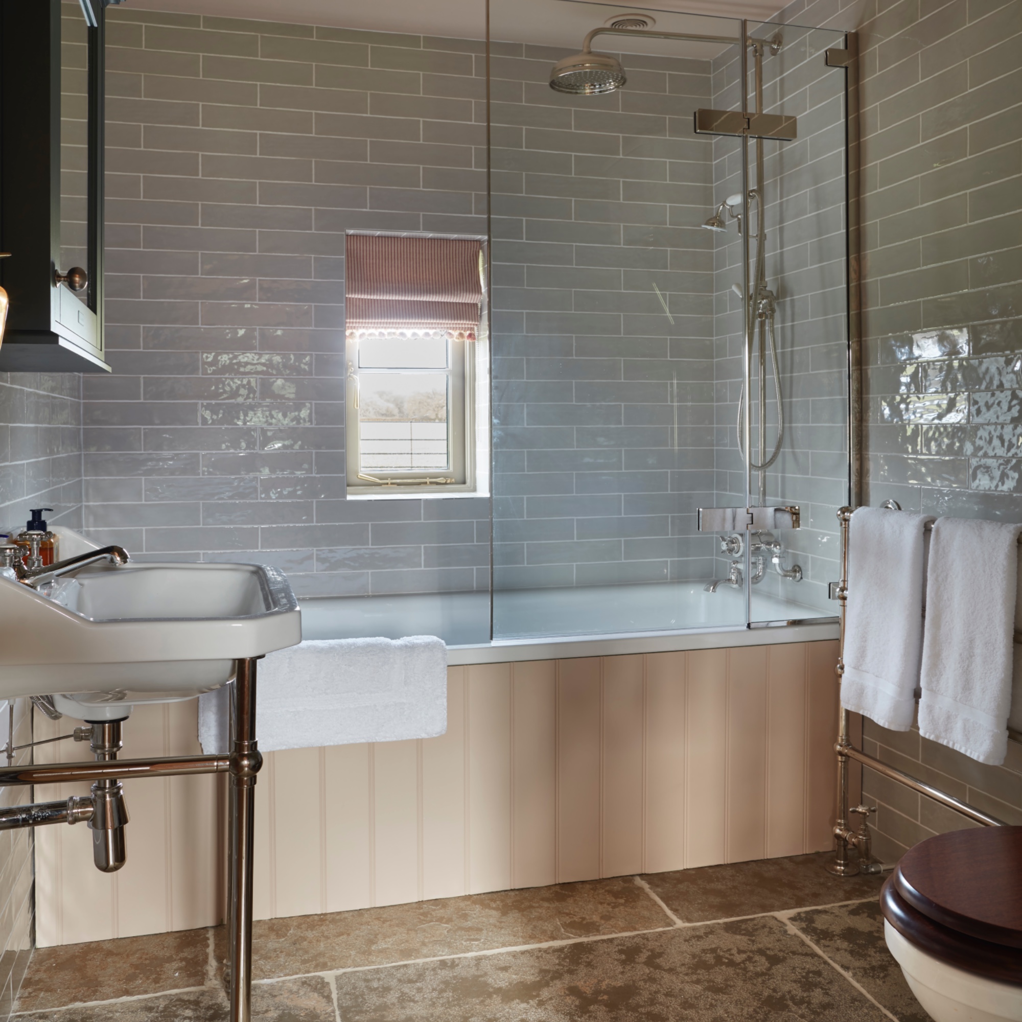 pale blue and coral pink bathroom with gloss metro tiles and tongue and groove bath surround