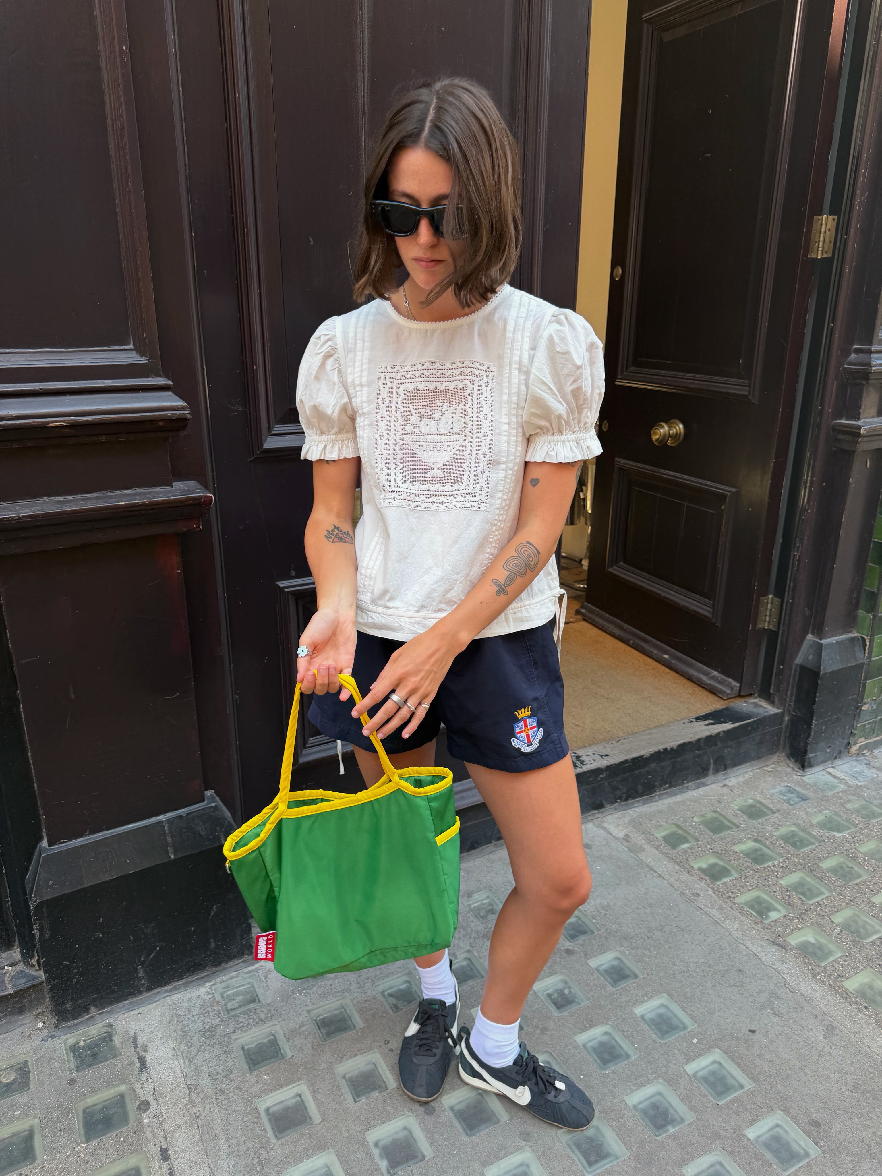 Influencer Poppy Almond wearing a boho top, athletic shorts and tote bag.