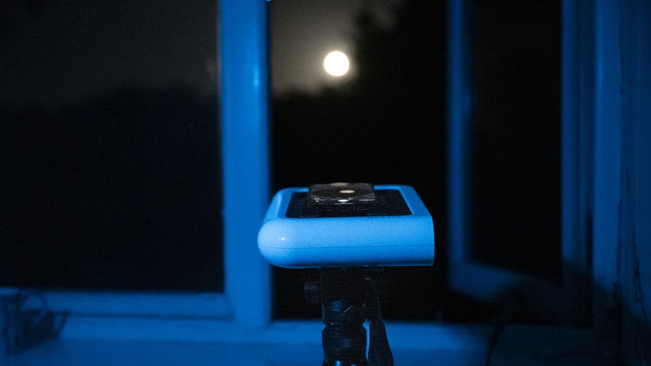 Vaonis Hestia smart telescope on a tripod pointing up at the night sky with a Google Pixel phone attached