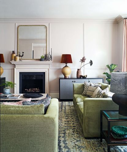 Pale pink living room with green velvet couches