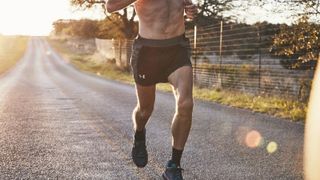 Person running on a dirt road in UA running shorts