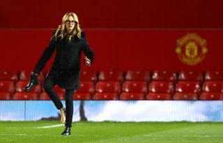 Julia Roberts takes off a shoe to walk on the Old Trafford pitch after a game between Manchester United and West Ham in 2016.