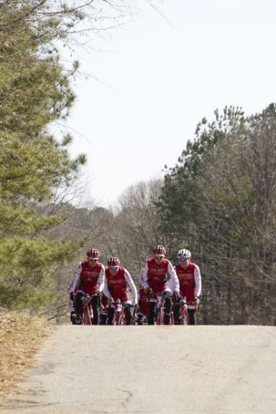 Kenda Pro Cycling presented by Geargrinders riders crest a hill.