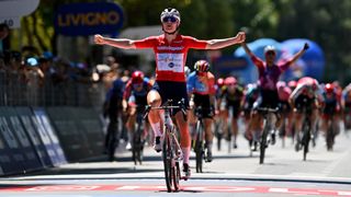 Lotte Kopecky, in a red top and black shorts, wins a cycling road race stage ahead of the 2024 Olympic Games.