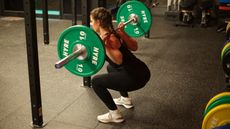 Pippa Sealey performs a barbell squat in a gym