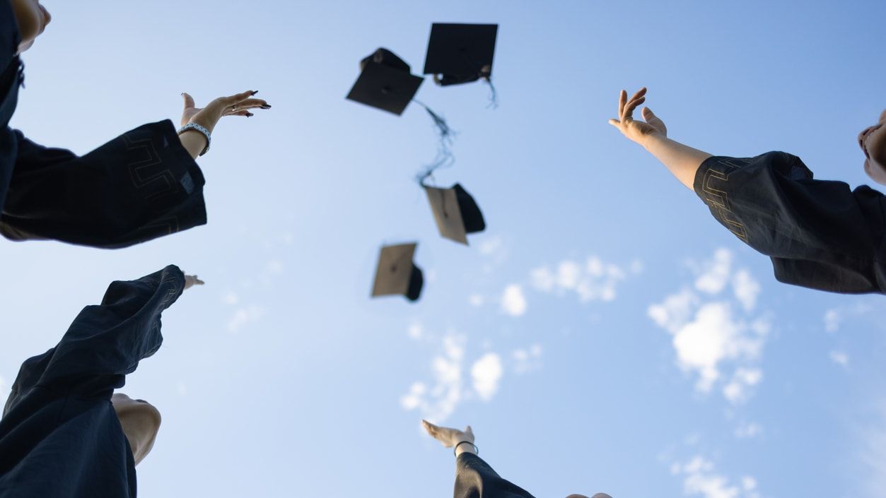 Graduates throw their caps.