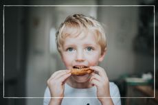 young boy eating a bagel
