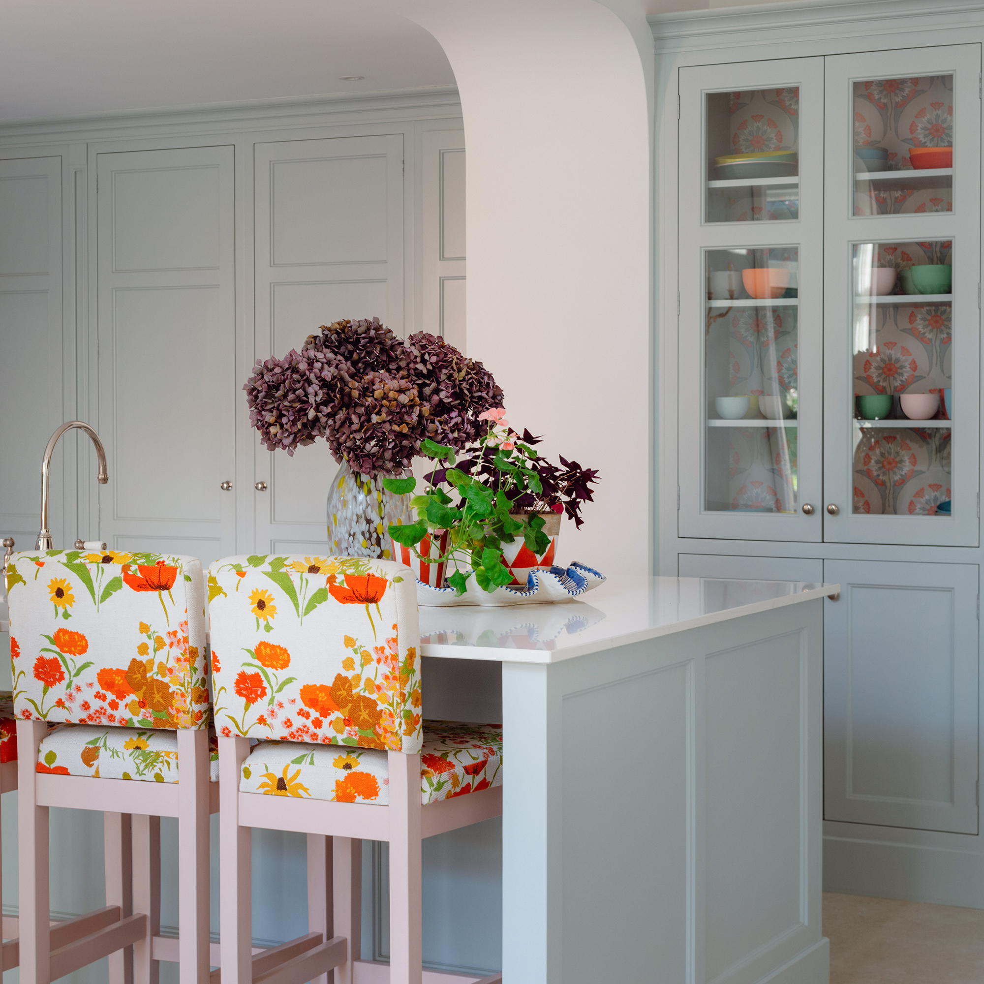 pale blue kitchen with island and bright upholstered bar stool