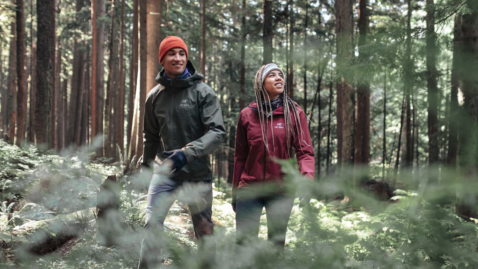Two hikers in the woods wearing Arc'teryx Beta Sl rain jackets
