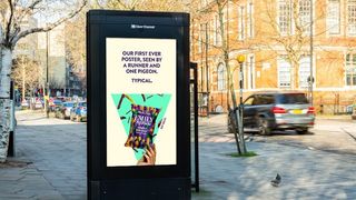 Poster in an empty street with the slogan: "Our first ever poster, seen by a runner and one pigeon. Typical."