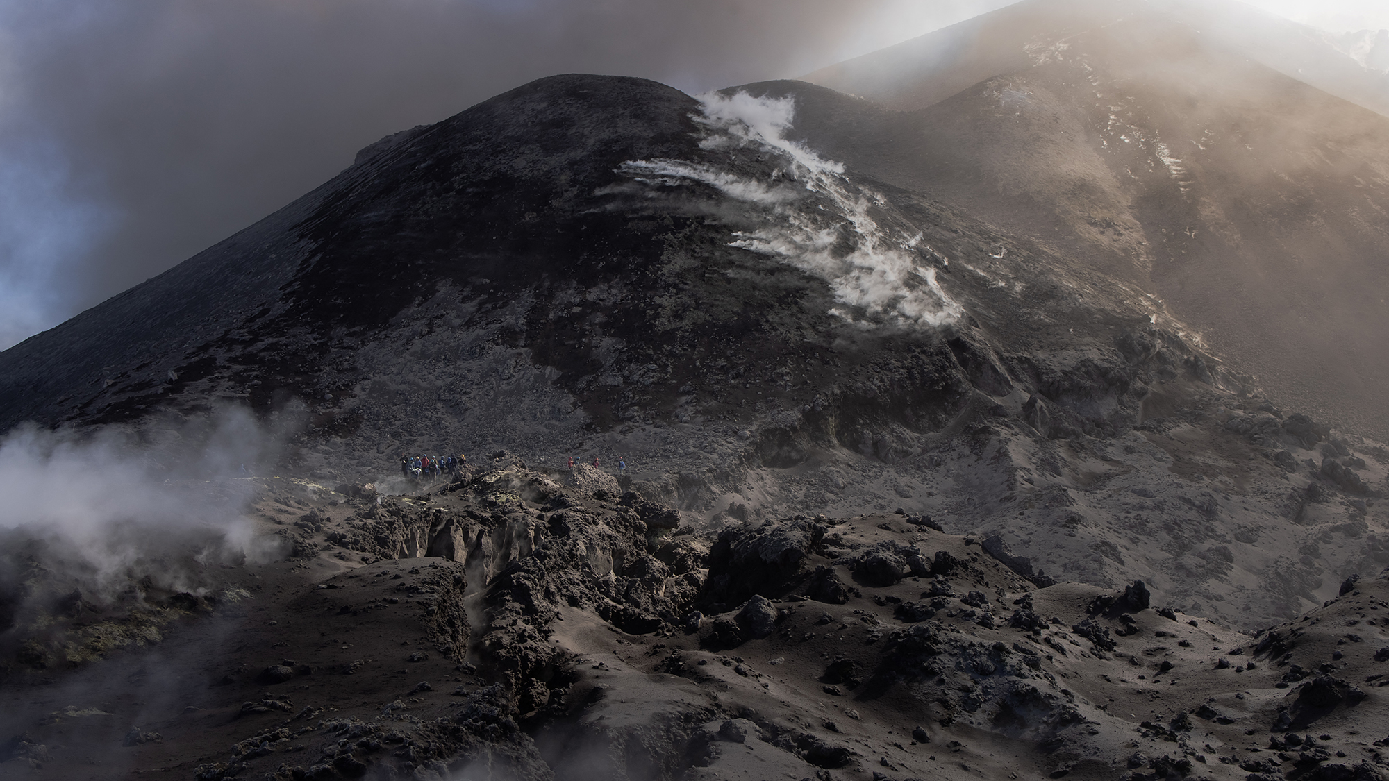 A group of tourists climb Mount Etna amid a haze of volcanic smoke, on the island of Sicily, Italy